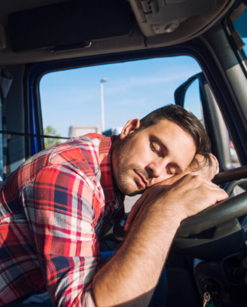 Condutor dormindo ao volante de um ônibus estacionado